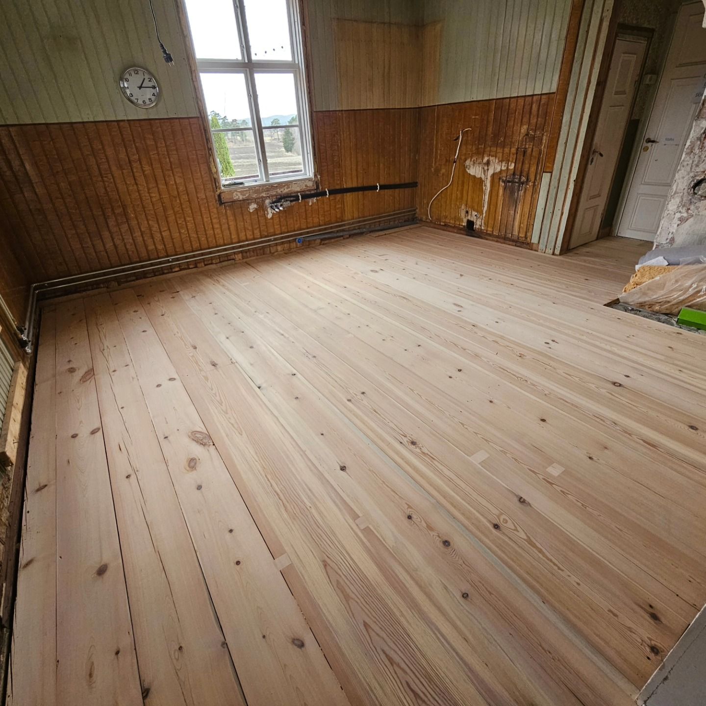Nylagt gammalt plankgolv i ett kök under renovering